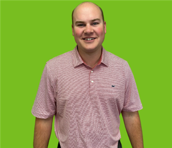 White male on green background in red striped shirt 