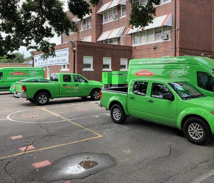 SERVPRRO vehicles lined up in front of commercial property 