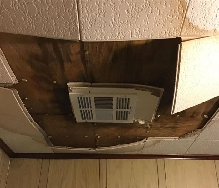 under ceiling exposed with brown water damage staining 