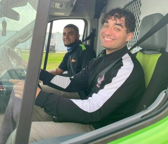 two male SERVPRO employees sitting in SERVPRO truck