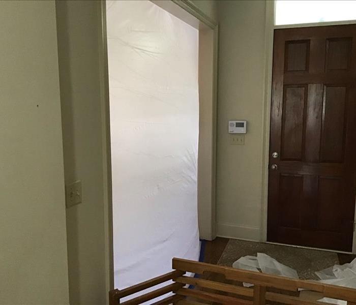 door covered in plastic to prevent mold spreading