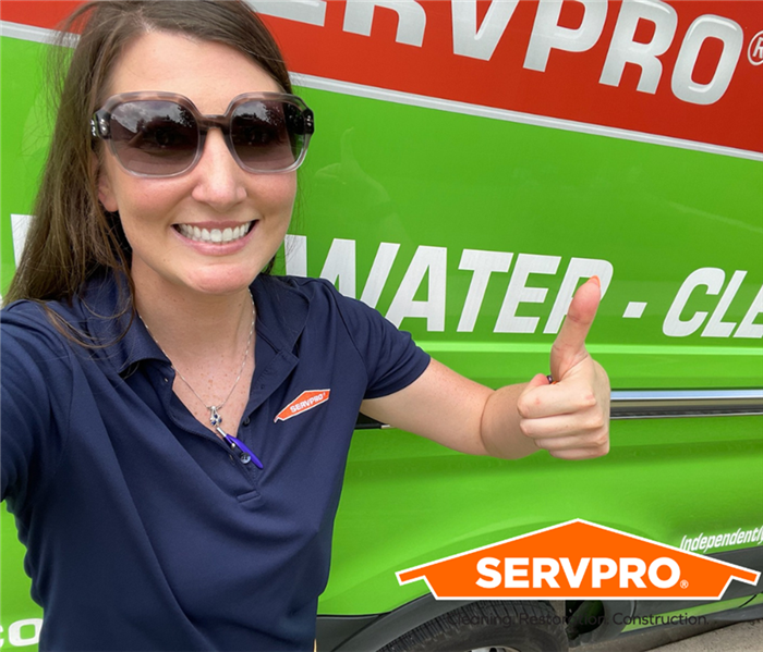 Kacey, our mold Production Manager, giving a thumbs up in front of SERVPRO Van. 