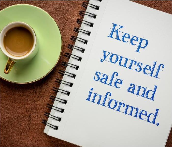 Cup of coffee and notebook that says keep yourself safe and informed 