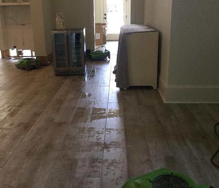 Room with wooden floors that has water on them